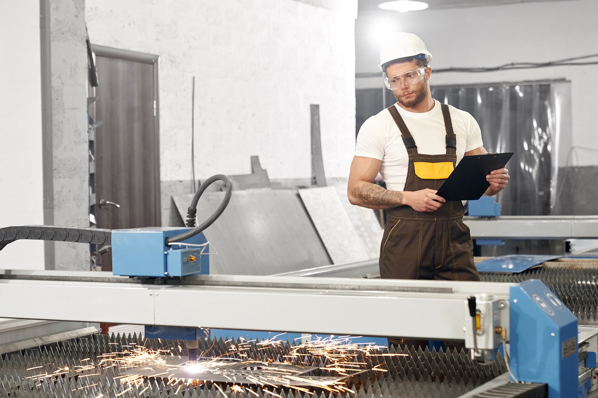 Serious man in protective glasses and helmet keeping folder