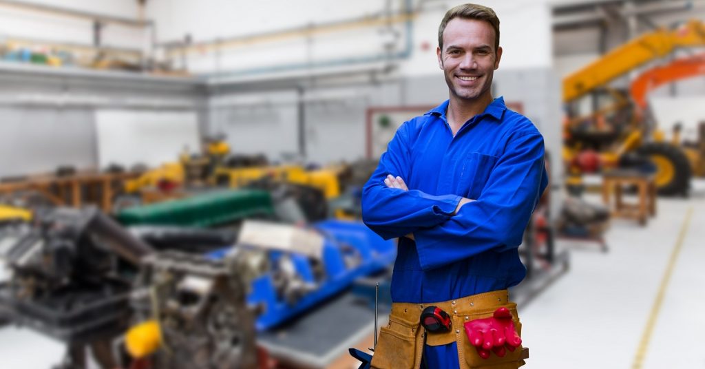 Mechanic standing with arms crossed in factory