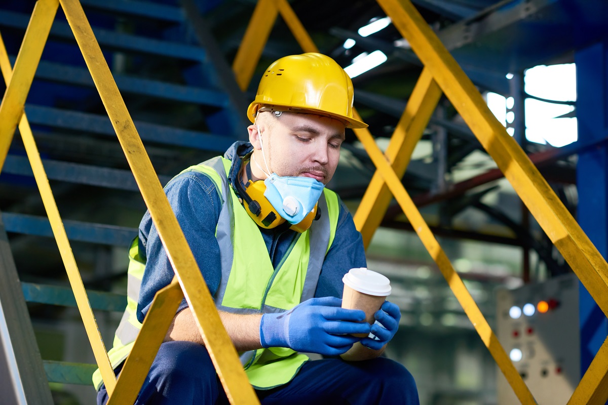 Young Man Taking Coffee Break at Plant