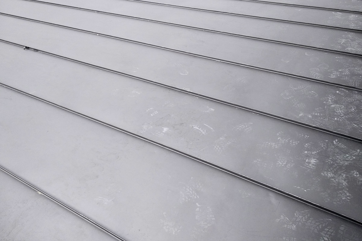 Close-up detail of house roof made from gray metal sheets.