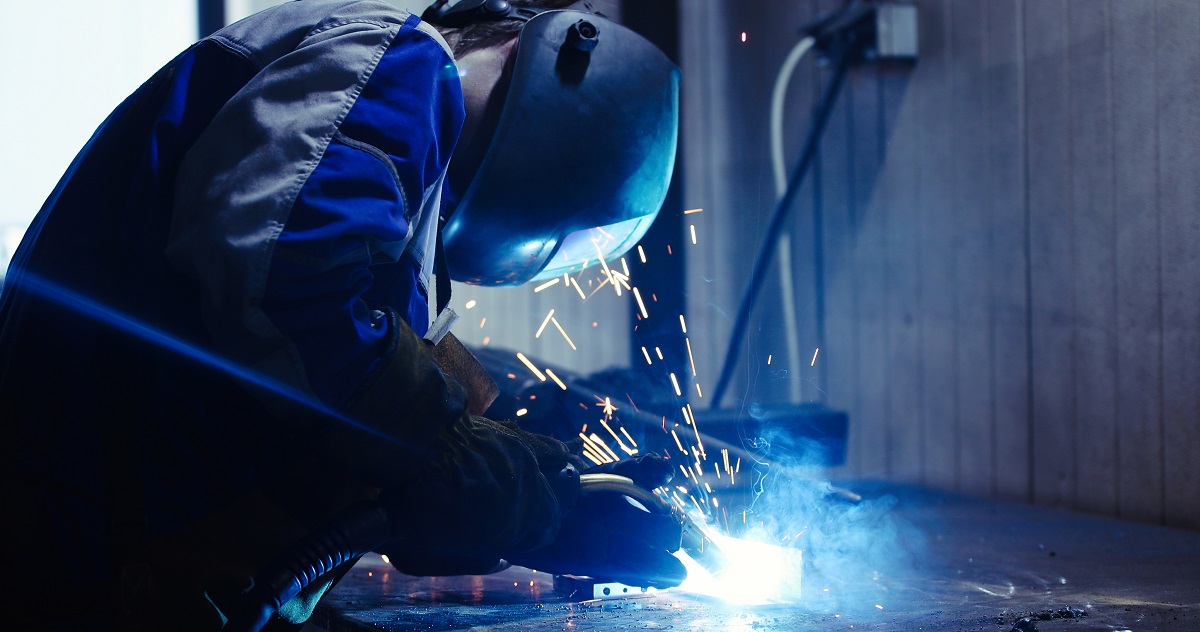 Industrial Worker at the factory welding metal closeup