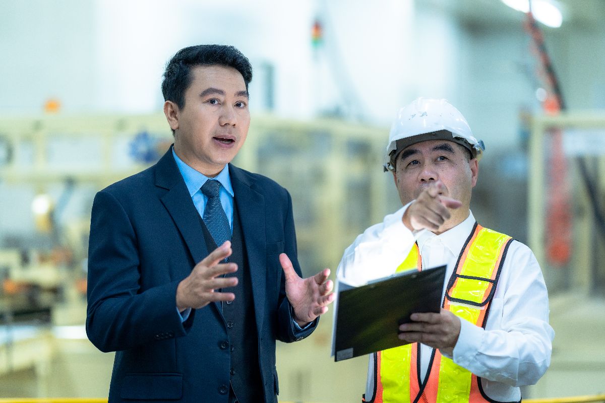 Engineer and business professional discussing construction supply chain operations