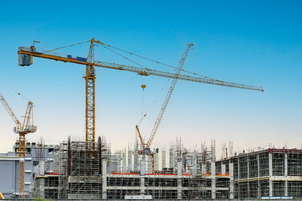 Construction site with cranes and building framework during material procurement