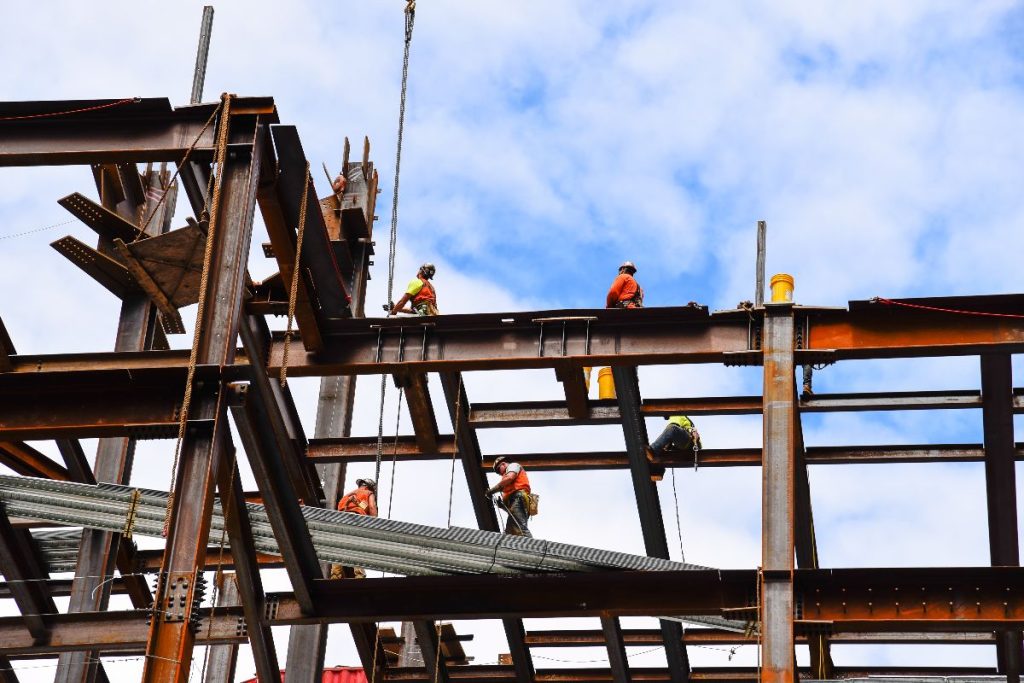 Construction workers installing steel beams on a building structure
