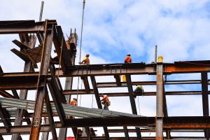 Construction workers installing steel beams on a building structure