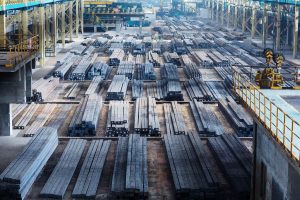 Large indoor steel storage facility with organized stacks of metal materials