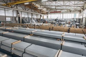 Heavy steel beams organized with timber supports inside a warehouse