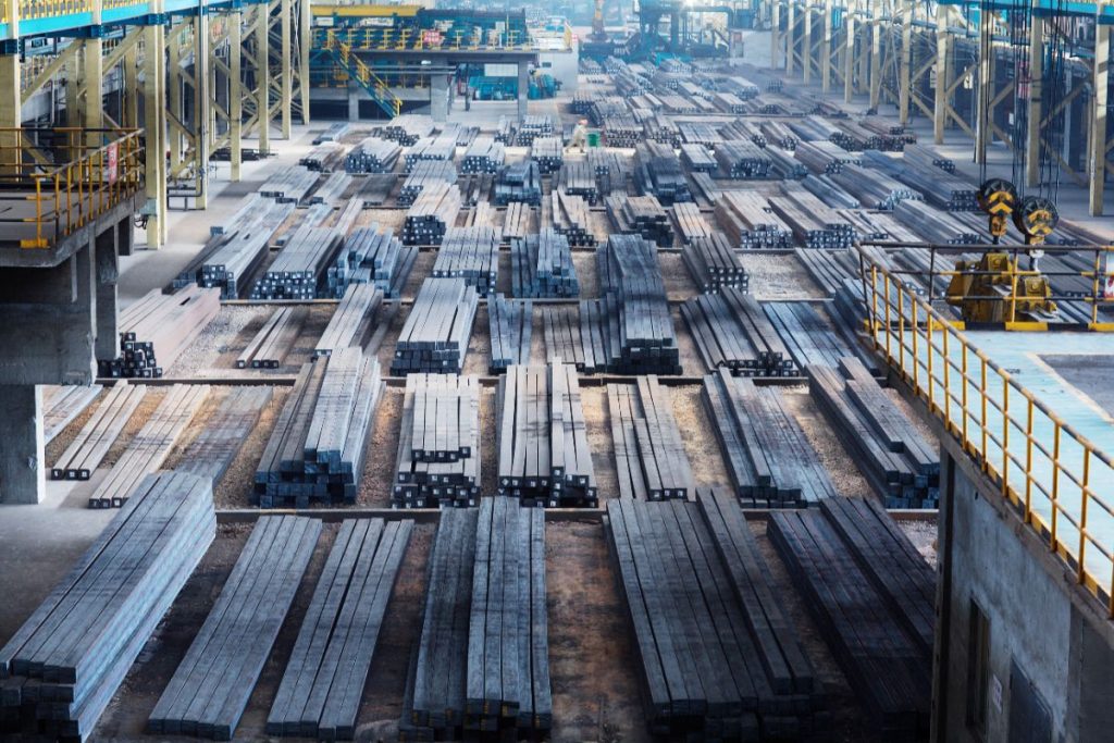 Large warehouse with rows of stainless steel bars prepared for industrial supply