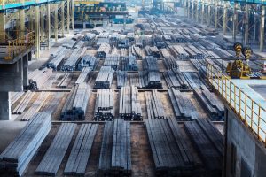 Large warehouse with rows of stainless steel bars prepared for industrial supply