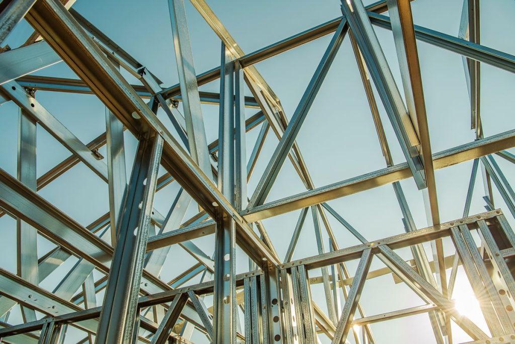 Galvanized steel framing assembled into a structural framework under a clear blue sky