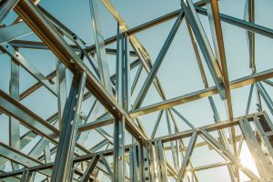 Galvanized steel framing assembled into a structural framework under a clear blue sky