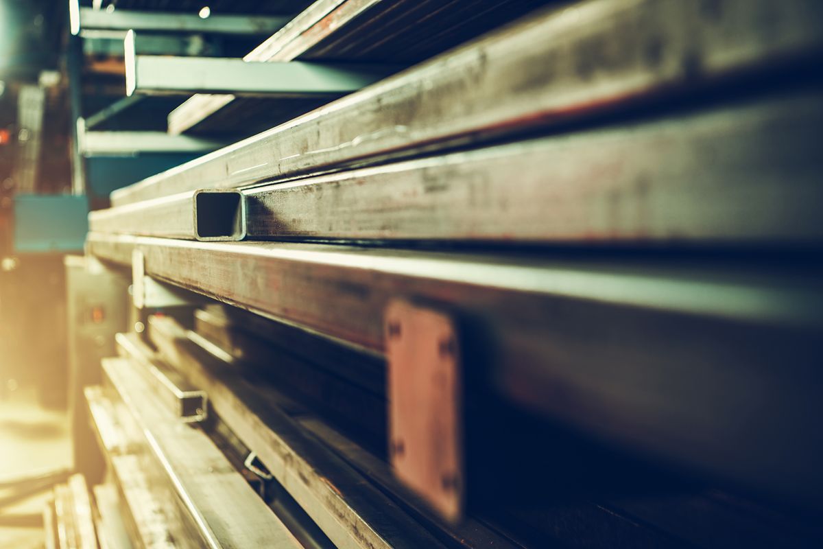 Close-up of rectangular steel tubes stacked in an industrial warehouse